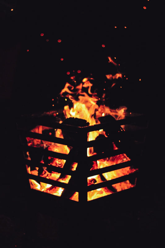 A fire pit in the dark with flames coming out of it