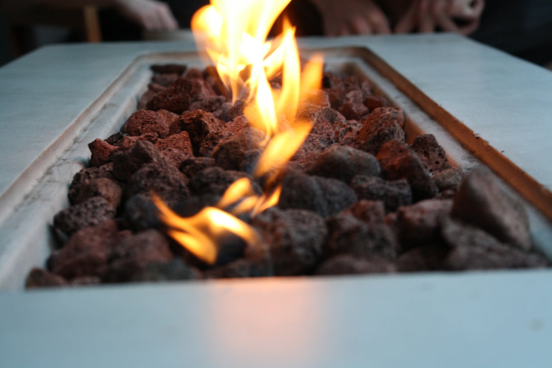 Flames dance above lava rocks in a fire pit.